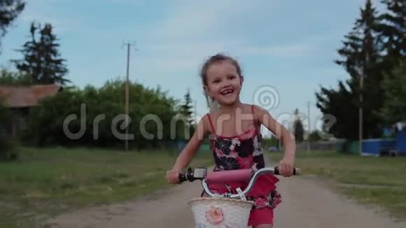 可爱的小女孩在乡下骑自行车她开心微笑笑视频的预览图