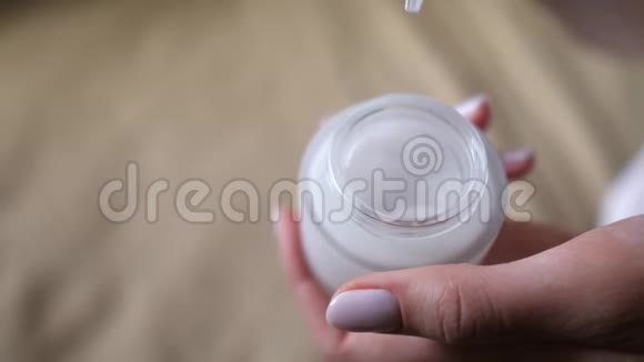 化妆品白色罐子一只带铲子的女性手可以为面部皮肤取出保湿霜健康卫生视频的预览图