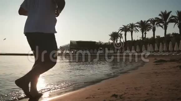 日落时分一个人在海滩上奔跑的剪影积极健康的生活方式理念视频的预览图