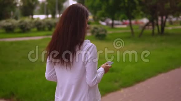 女商人在户外手机上打字视频的预览图