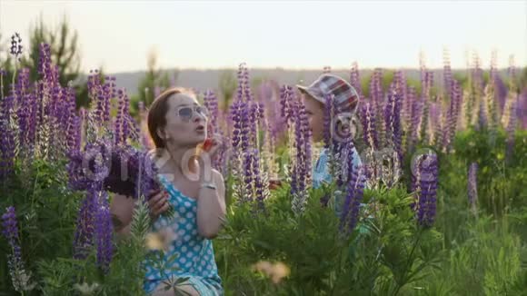 一家人幸福的母亲和孩子抱着野花在草地上视频的预览图
