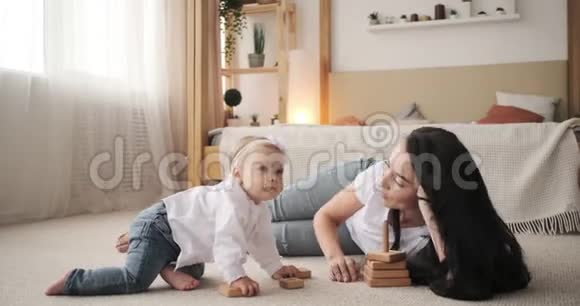 妈妈和小女儿躺在地毯上玩玩具视频的预览图