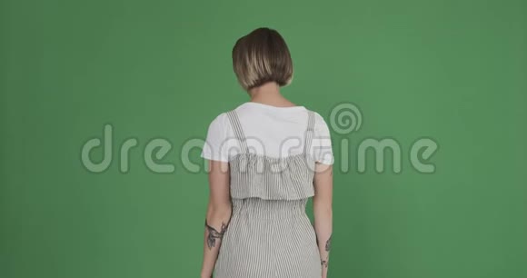 兴奋的女人挥舞着手在绿色的屏幕上打招呼视频的预览图