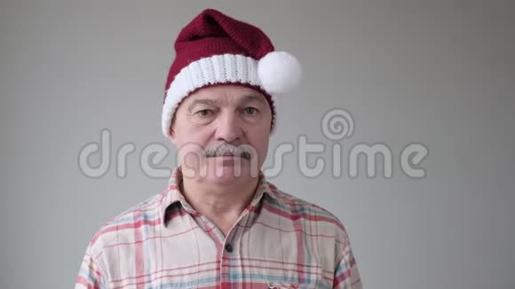 西班牙裔悲伤的老人摘下红色圣诞帽因为假期结束了视频的预览图