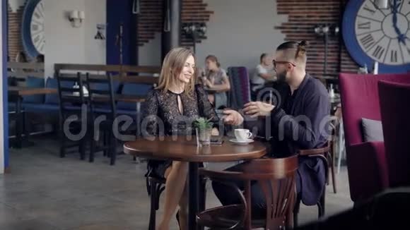 好客的年轻女服务员把棕色陶瓷杯的饮料带到餐桌上给女人一对夫妇坐在视频的预览图
