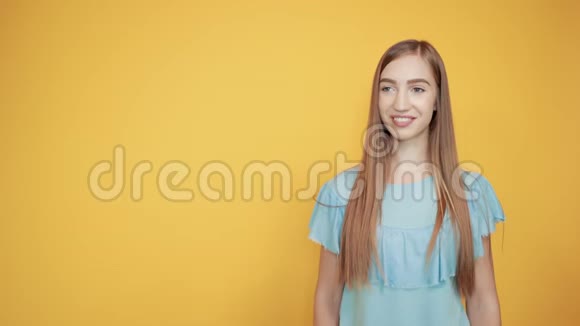 穿着蓝色t恤橙色背景的浅黑色女孩表现出情感视频的预览图