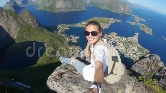 年轻女性视频博客作者在悬崖边拍一张自拍照上面可以看到视频的预览图