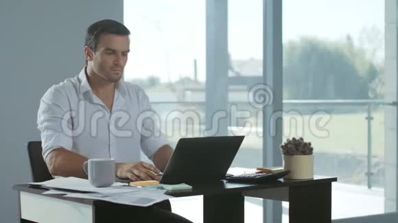 商人在豪宅里关闭手提电脑累的男性整理工作视频的预览图