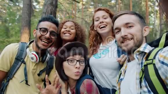 快乐的女孩和男人在树林里自拍拿着相机玩得开心视频的预览图