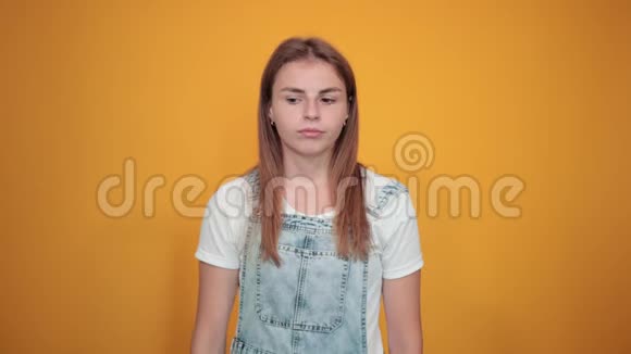 穿着白色t恤的年轻女性橙色背景显示出情绪视频的预览图