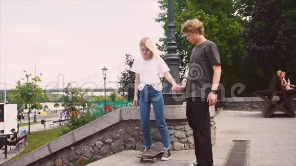 那家伙在教他女朋友玩滑板一个嬉皮士的约会对象视频的预览图