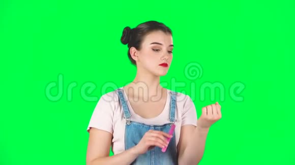女孩在演播室的绿色屏幕上用红色的大耳机跳舞唱歌视频的预览图