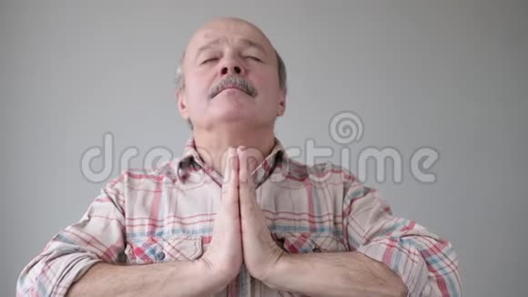 冷静放松资深西班牙裔男子站在手掌闭上眼睛和做瑜伽冥想视频的预览图