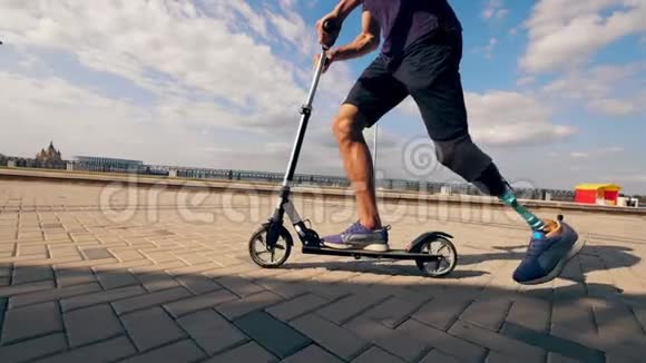 滑板车是由一个动作缓慢的仿生腿男子驾驶的视频的预览图
