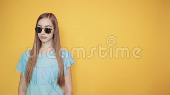 穿着蓝色t恤橙色背景的浅黑色女孩表现出情感视频的预览图
