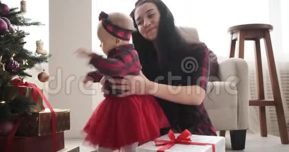 妈妈抱着小女儿玩圣诞树视频的预览图