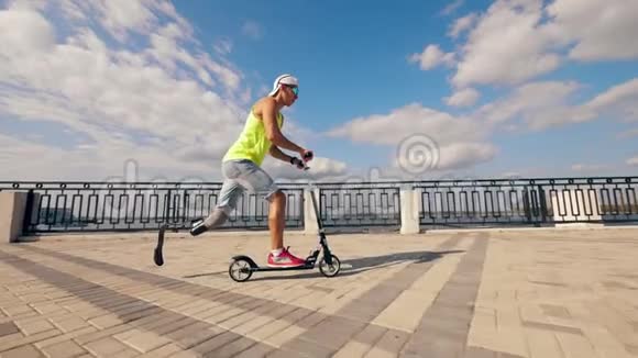 一个残疾人骑着滑板车沿着码头慢动作视频的预览图