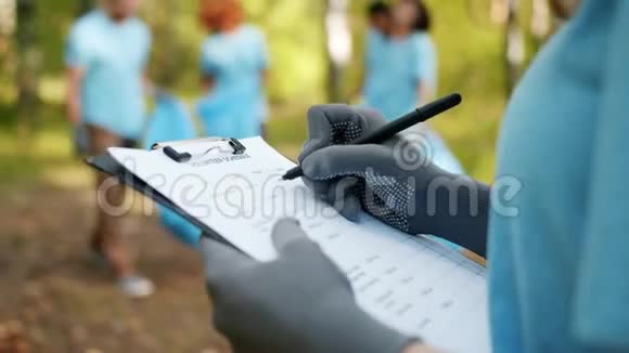 清理工作期间在森林中编写女性手工志愿报告视频的预览图