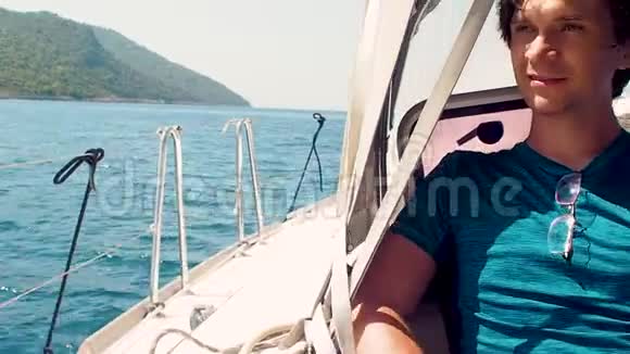在海上休息在游艇上乘船旅行一个穿蓝色t恤的年轻人视频的预览图
