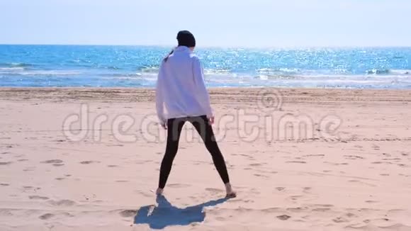 女初学者尝试做三角瑜伽姿势并落在沙滩上视频的预览图