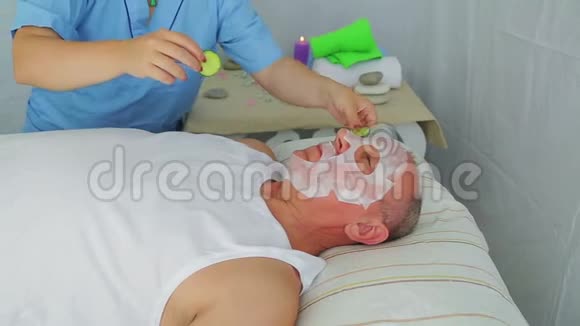 一个女性美容师把保湿面膜贴在男人脸上视频的预览图