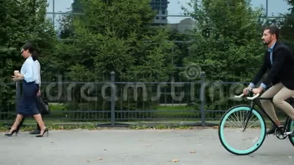 夏天早上骑自行车去办公楼的英俊活跃的商人视频的预览图