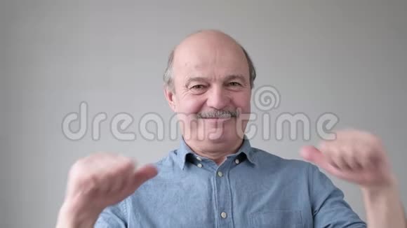 积极向上的秃顶老人胡子笑着用手指指着自己视频的预览图