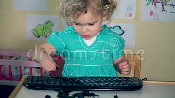 淘气的小女孩移除黑色键盘上的按钮4K视频的预览图
