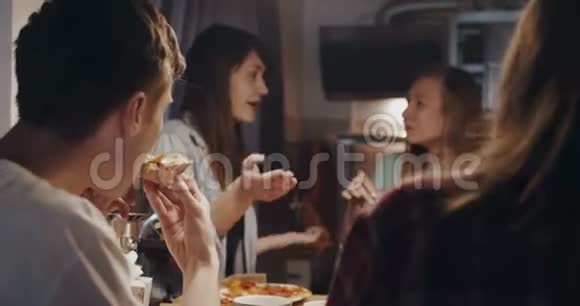 近距离快乐的年轻多民族学生朋友吃披萨在轻松的休闲屋聚会上聊天慢动作视频的预览图