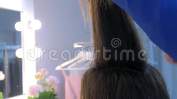 发型师与长发女孩合作准备把折叠的头发剪成发髻视频的预览图
