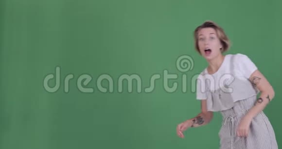 兴奋的纹身女人用双手在绿色屏幕上打招呼视频的预览图