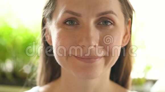 一个成年女人看着画框微笑的肖像视频的预览图