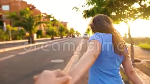 跟着我快乐的年轻女子拉着男孩手牵着手在灿烂的阳光下奔跑视频的预览图