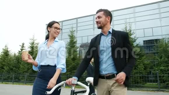 商人和女商人从工作中散步男人拿着自行车视频的预览图