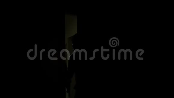 男性罪犯带着手电筒来到黑暗的公寓私人财产安全视频的预览图