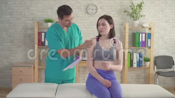 医生的年轻女性脊椎按摩师骨病师抱怨前臂疼痛视频的预览图