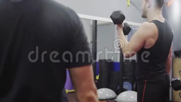 男子训练肱二头肌与哑铃在健身房特写视频的预览图