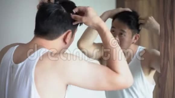 年轻的亚洲人在浴室里做发型视频的预览图