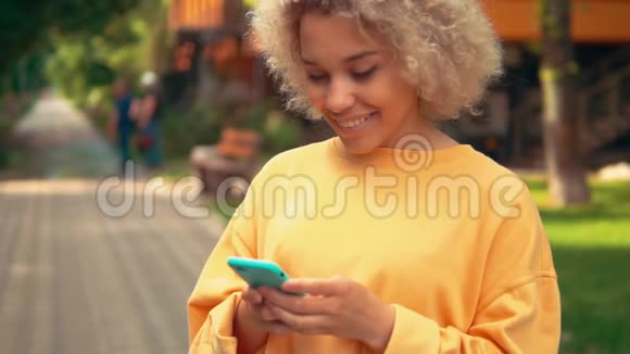 金发女性在户外使用智能手机视频的预览图