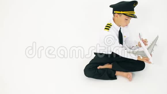 穿着飞行员制服男孩玩玩具商用飞机视频的预览图