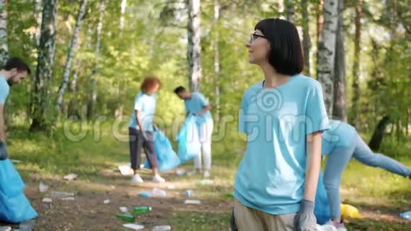 现代年轻女性生态活跃分子在森林里对着镜头微笑视频的预览图