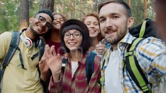 一幅快乐的年轻人在森林里自拍的照片视频的预览图