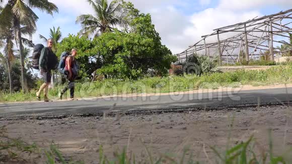 在非洲水泥路上行走的背包游客视频的预览图