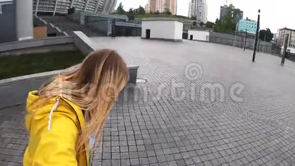 在城市的街道上一位金发女时髦女郎骑在长板上视频的预览图