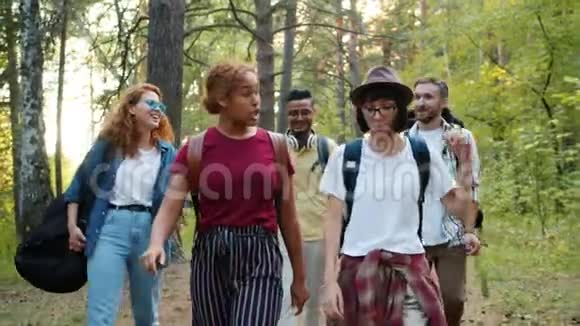 年轻男女在树林里散步一起做五人行视频的预览图