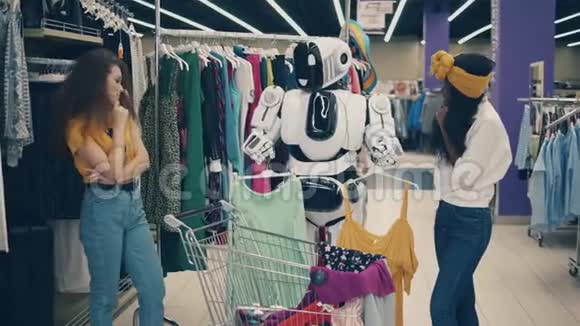 人类机器人正在帮助两个女人挑选衣服视频的预览图