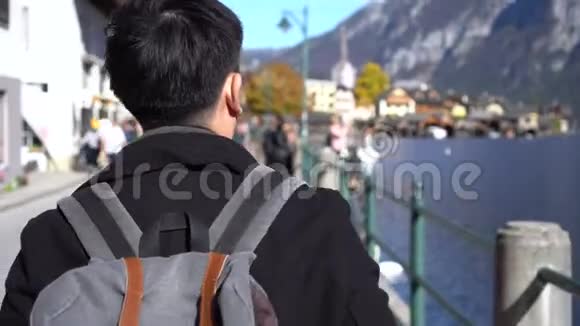 在奥地利旅行期间亚洲年轻人在萨尔茨卡梅尔古特的霍尔斯塔特湖购物和观看纪念品视频的预览图