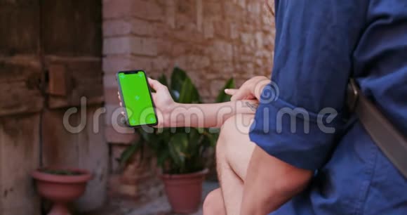 两个人在Spello农村小镇自拍或使用绿色Screeen智能手机设备肖像中等镜头朋友视频的预览图