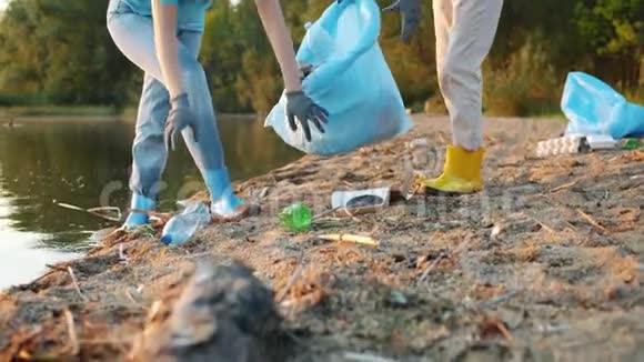 在海滩上捡垃圾的两名女性生态活动家的倾斜视频的预览图
