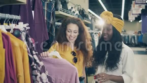 2两位兴高采烈的女士正在店里看一件毛衣视频的预览图